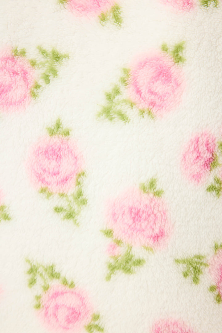 A close-up of the Lets Get Cozy Floral Print Shorts by P.J. Salvage, featuring soft white fabric adorned with pink roses and green leaves.