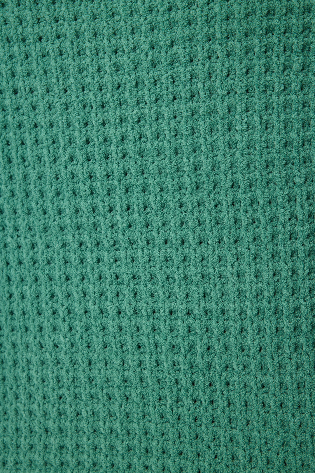 Close-up of the P.J. Salvage Chenille Waffle Solid Forest Sweater highlights its green waffle knit fabric with a textured square pattern, featuring small raised sections and recessed lines running vertically and horizontally.