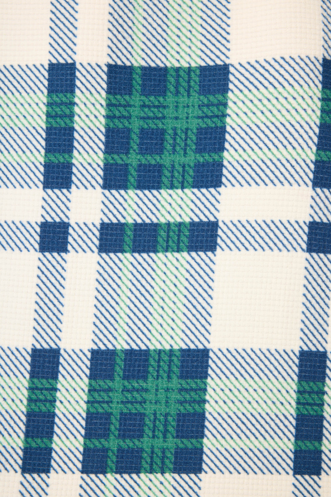 A close-up of the Cozy Life Plaid Velour Thermal Long Sleeve Top by P.J. Salvage, showing its grid-like plaid pattern with intersecting blue, green, and white lines on a textured white background.