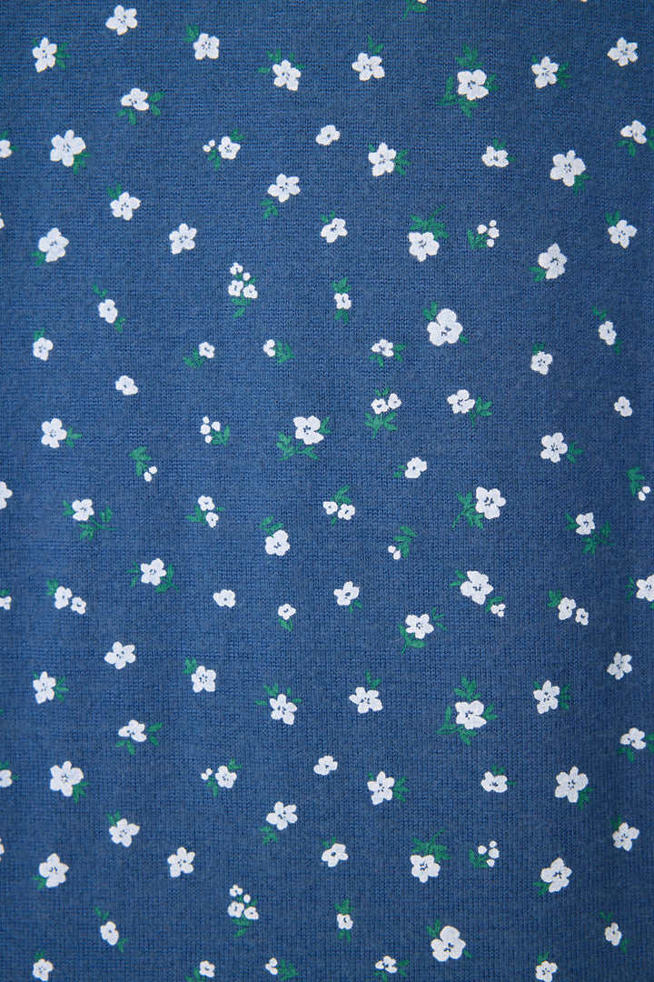 The P.J. Salvage Cozy Life Floral Long Sleeve Top features blue fabric adorned with small white flowers and green leaves in an even pattern.