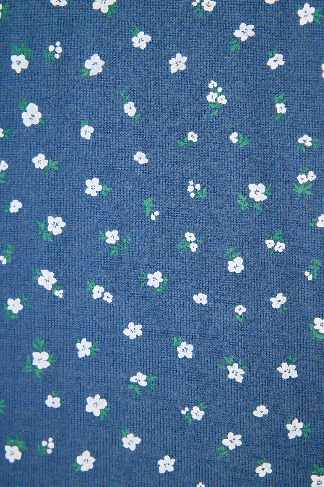 The P.J. Salvage Cozy Life Floral Banded Pant features a blue fabric adorned with a repeating pattern of small white flowers and green leaves scattered evenly across the surface.