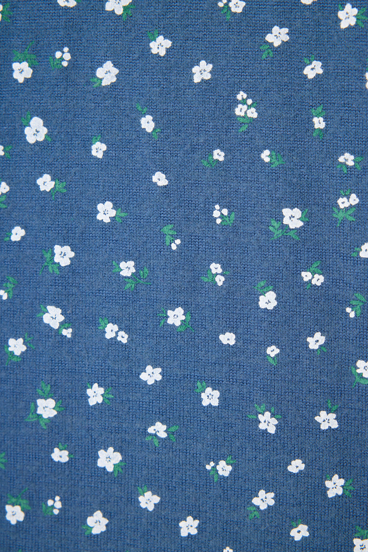 The P.J. Salvage Cozy Life Floral Banded Pant features a blue fabric adorned with a repeating pattern of small white flowers and green leaves scattered evenly across the surface.