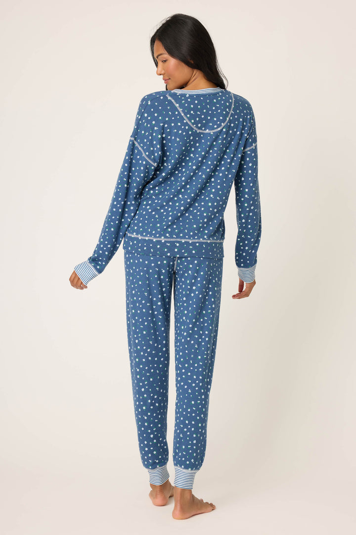 A person stands barefoot facing away from the camera, wearing the P.J. Salvage Cozy Life Floral PJ Set, against a plain light background.