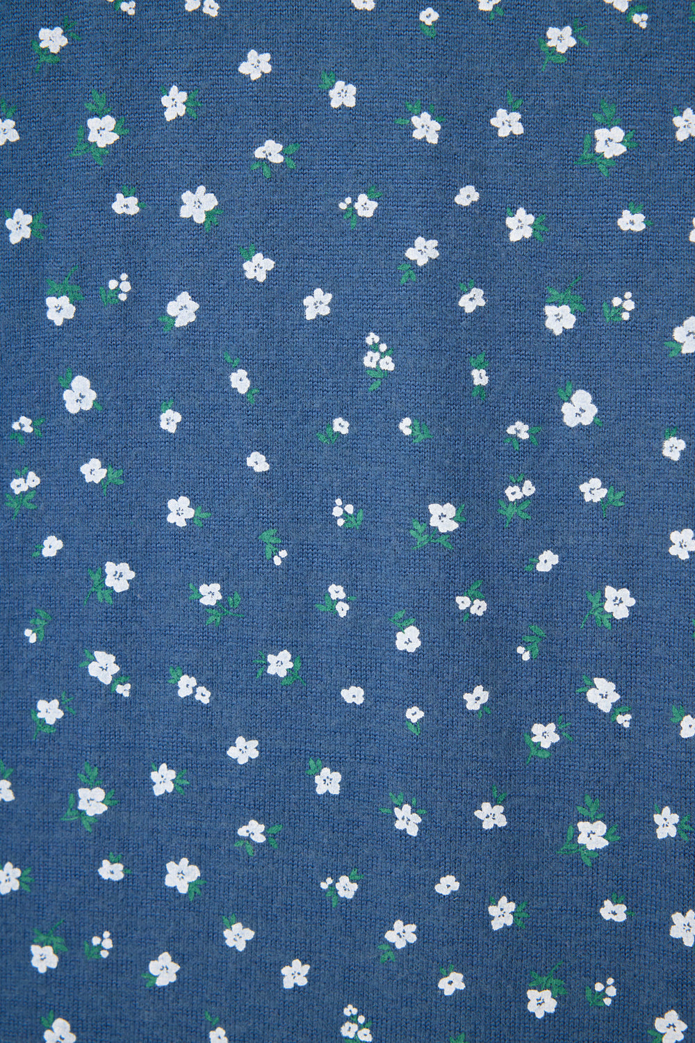 The Cozy Life Floral PJ Set by P.J. Salvage features a blue fabric adorned with small white flowers and green leaves scattered evenly across the surface.
