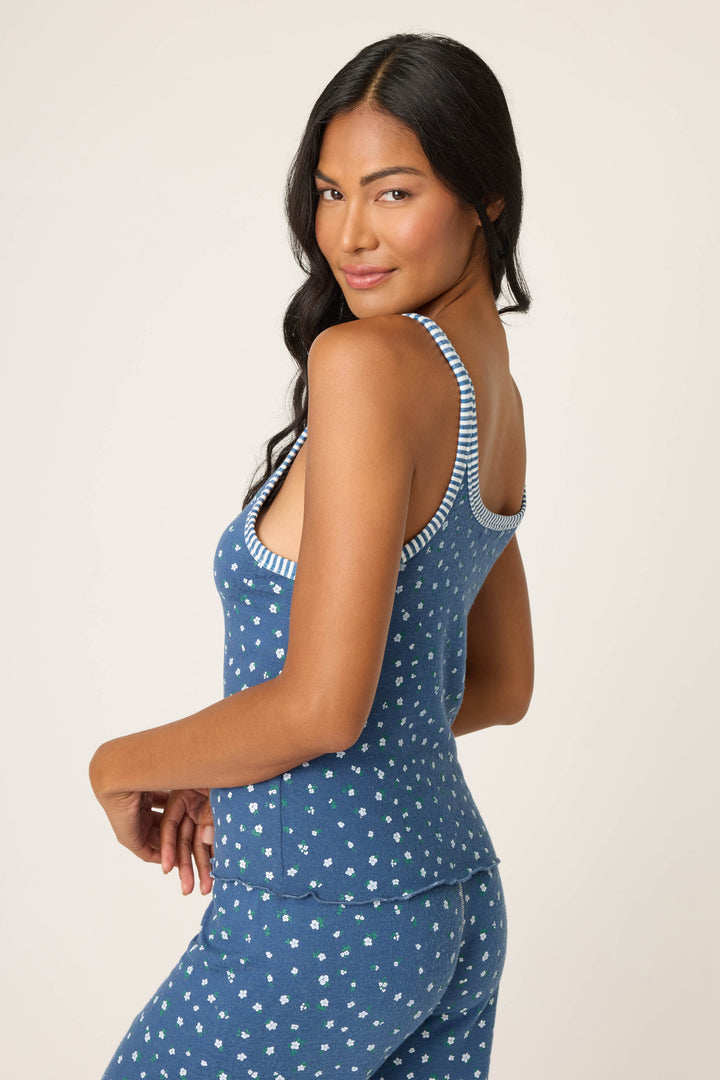 A woman with long dark hair wears the P.J. Salvage Cozy Life Floral Camisole, posing sideways and looking over her shoulder at the camera against a plain light background.