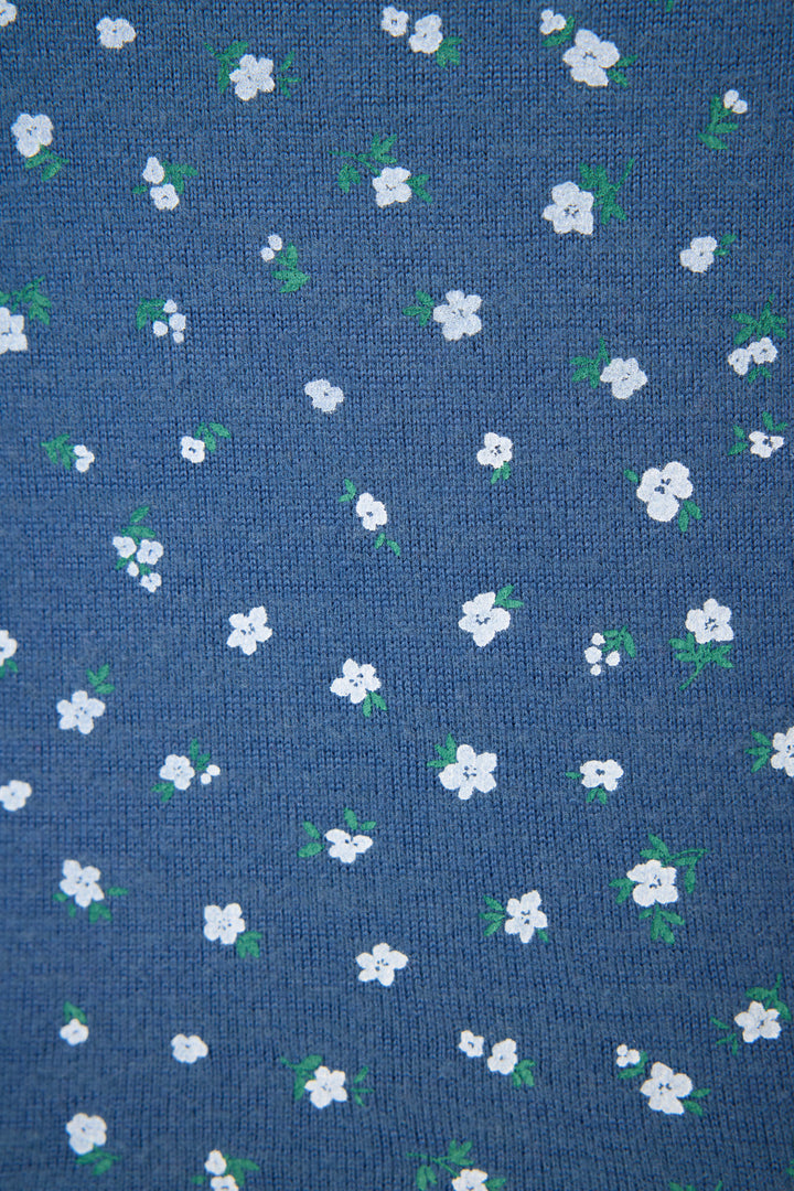 A close-up of the P.J. Salvage Cozy Life Floral Camisole shows blue fabric patterned with small white flowers and green leaves, evenly spaced across the surface.
