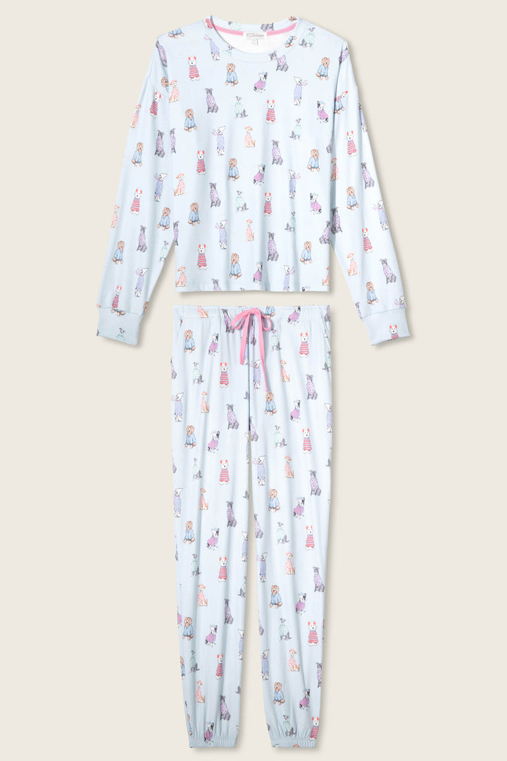 The P.J. Salvage Doggone Cold Dog Print Pointelle Lounge Set features a light blue long-sleeve top and elastic-cuffed pants with multicolored cartoon animal prints, a pink drawstring waist, and is displayed on a plain background.