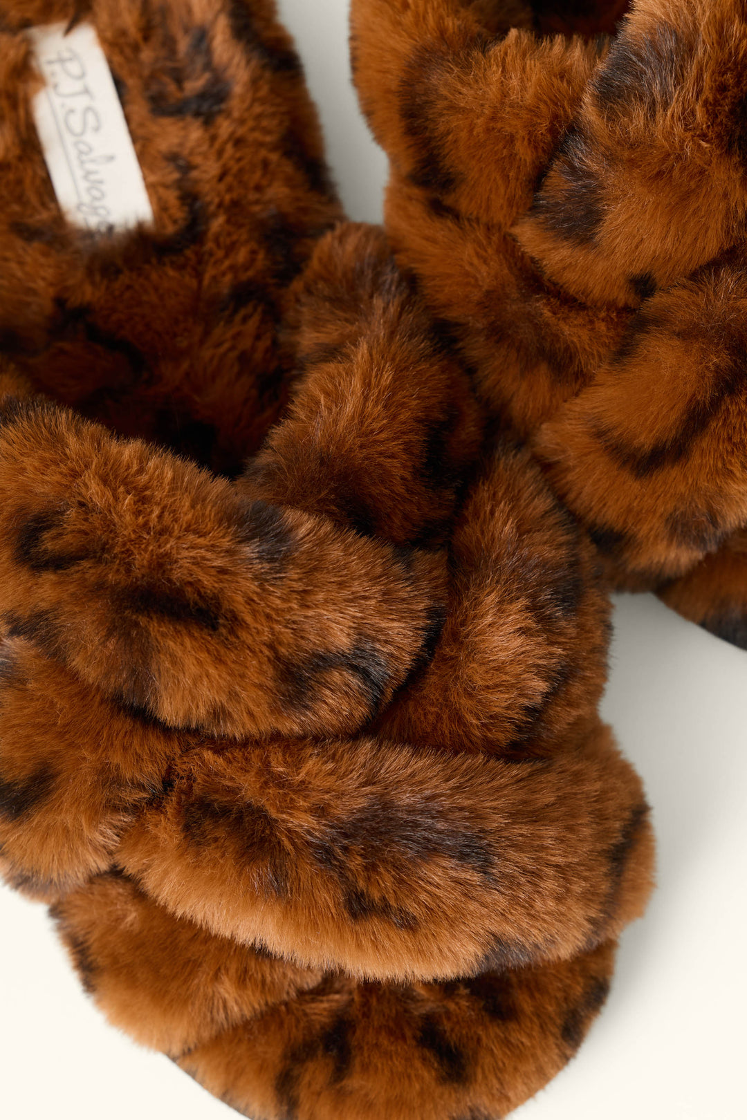 Close-up of P.J. Salvage Faux Fur Leopard Print Slippers featuring a soft, crisscross design and stylish animal print pattern.