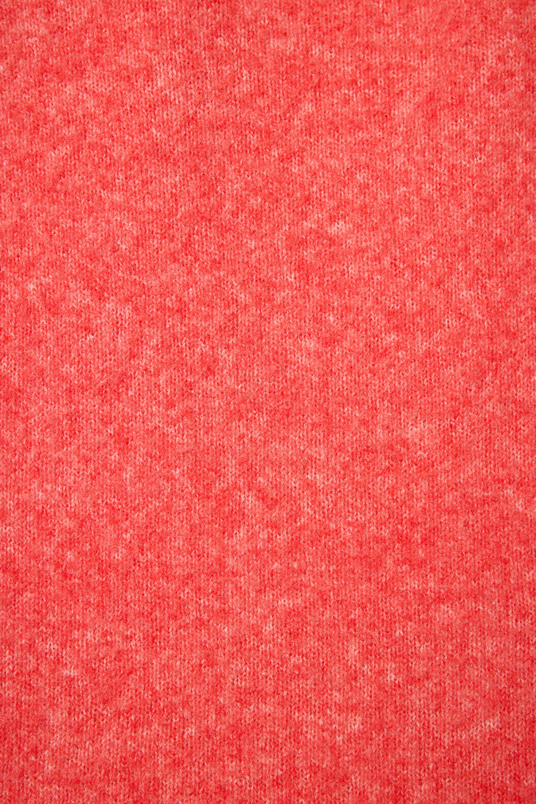 Close-up of the Sleigh Snuggle Sweater by P.J. Salvage, featuring a textured red fabric with a heathered pattern and subtle variations of lighter and darker red tones.