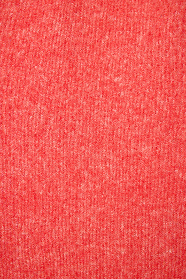 Close-up of the Sleigh Snuggle Sweater by P.J. Salvage, featuring a textured red fabric with a heathered pattern and subtle variations of lighter and darker red tones.