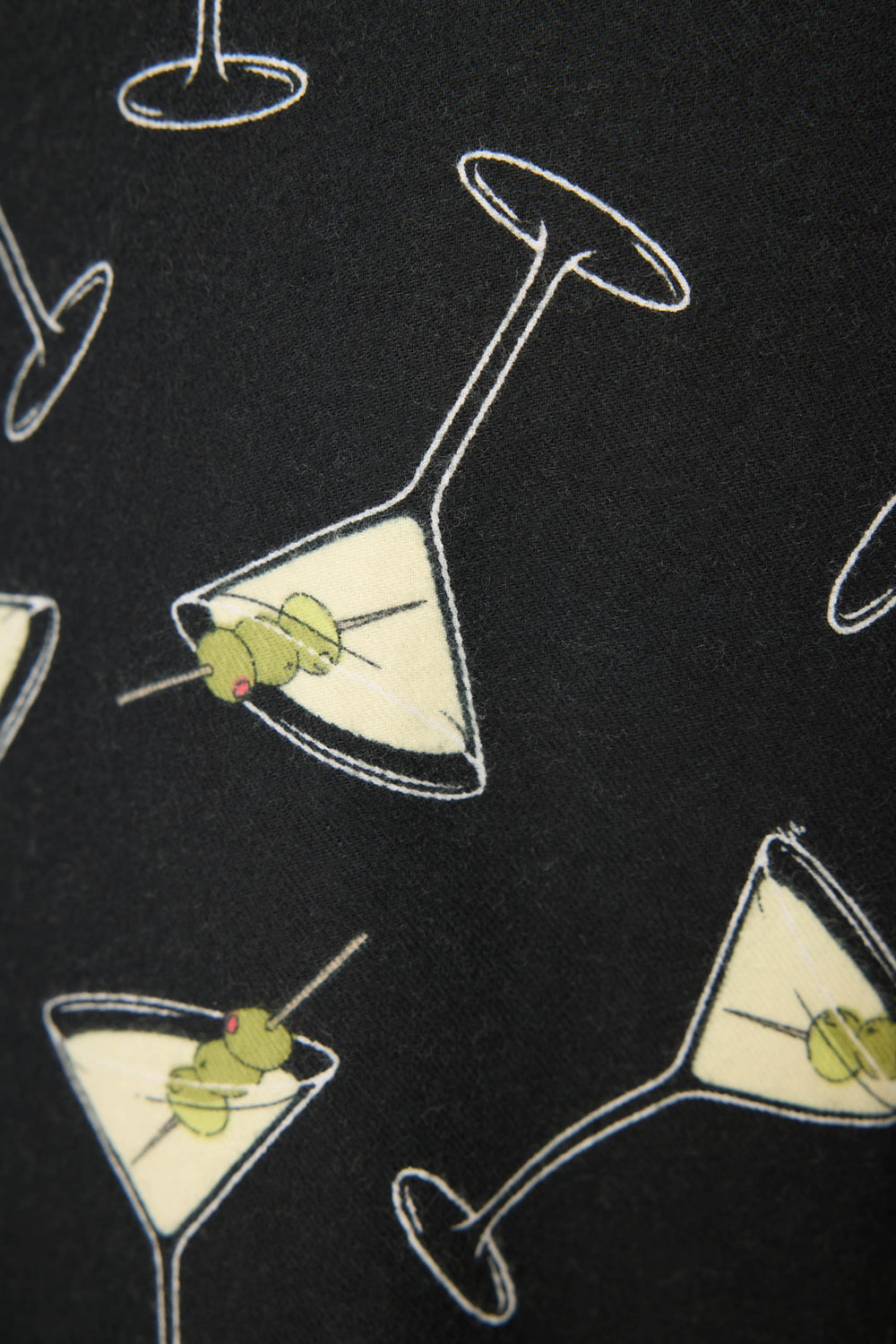 The Merrier With A Martini Flannel Pants by P.J. Salvage feature a black background with a repeating pattern of martini glasses filled with pale liquid and garnished with two green olives on a toothpick.