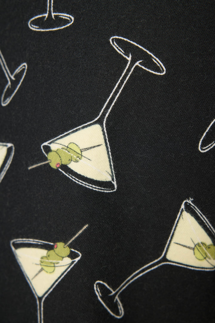 The Merrier With A Martini Flannel Pants by P.J. Salvage feature a black background with a repeating pattern of martini glasses filled with pale liquid and garnished with two green olives on a toothpick.