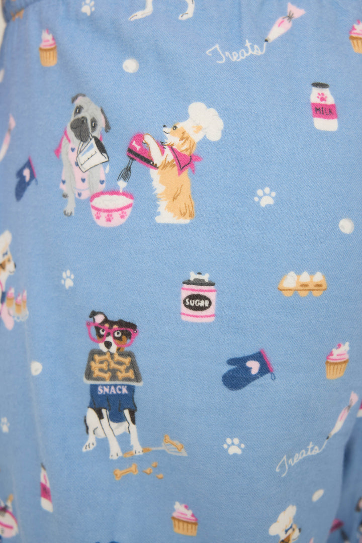 WILD PANT FLANNELS by P.J. Salvage feature blue fabric adorned with cartoon dogs baking—mixing bowls, sugar jars, eggs, oven mitts, treats, paw prints, and cupcakes create a playful pattern.