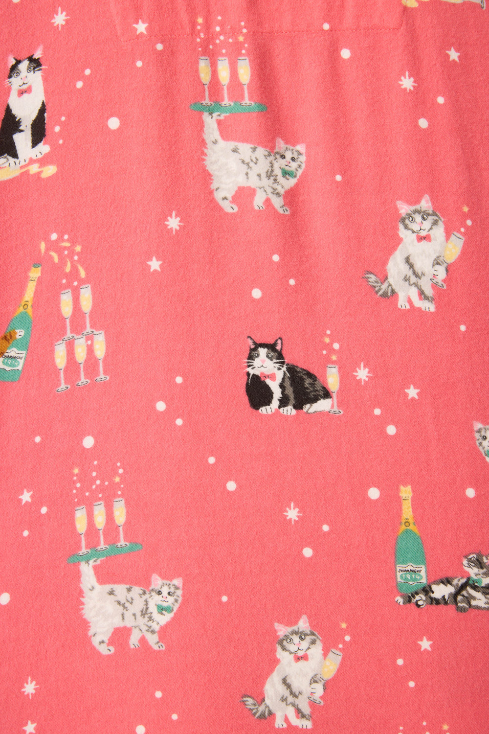 The Let's Get Fizzical Cat Print Flannel Plus Size PJ Set by P.J. Salvage features a playful pattern of fluffy cats, champagne bottles, and glasses on a pink background with white starburst accents.