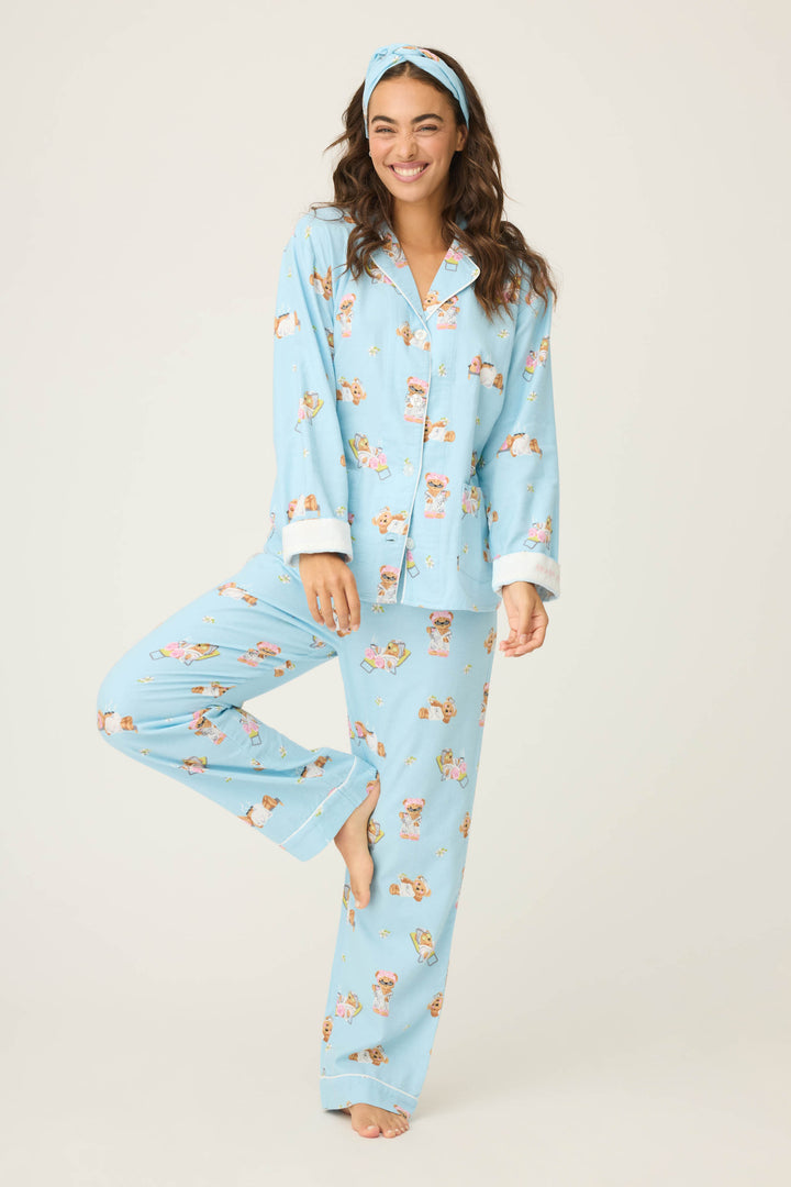 A person in the P.J. Salvage Beary Cute Bear Print Flannel PJ Set and matching headband stands barefoot on one leg, smiling against a plain light background.