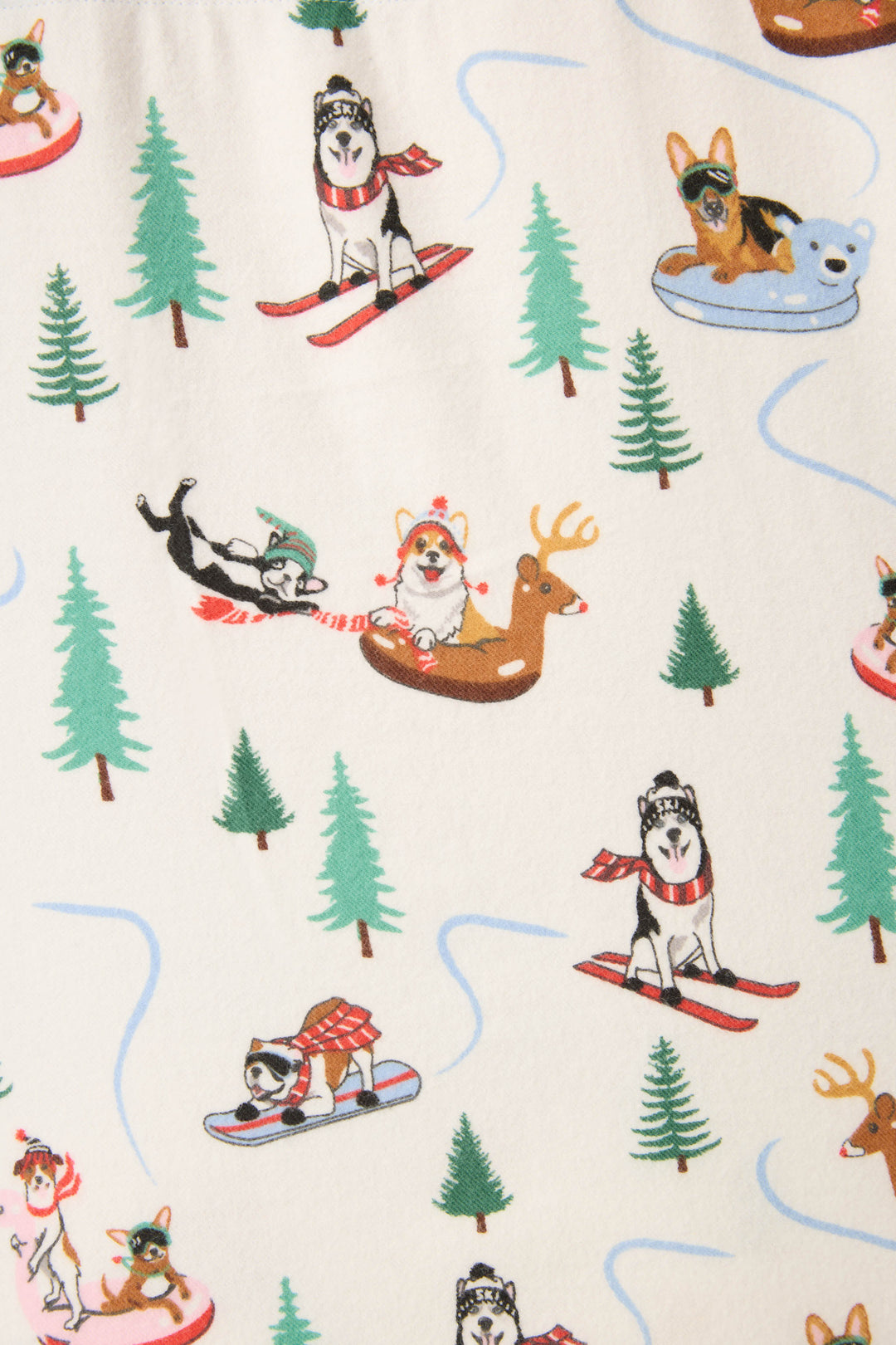 The P.J. Salvage Sleigh All Day Winter Print Flannel Plus Size PJ Set features illustrated dogs enjoying winter sports among green pine trees on a cream background.