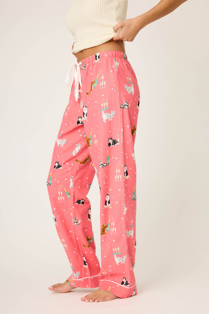 A person wearing P.J. Salvage's Let's Get Fizzical Cat Print Flannel Pant with a white drawstring stands sideways, adjusting the waistband; they pair it with a cream-colored ribbed tank top.