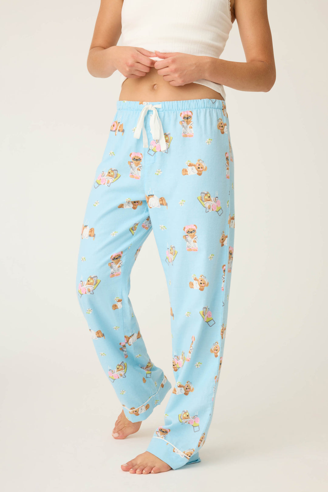 A person stands barefoot in P.J. Salvages Beary Cute Bear Print Flannel Pants with a white drawstring and a white cropped top; their face is not visible.