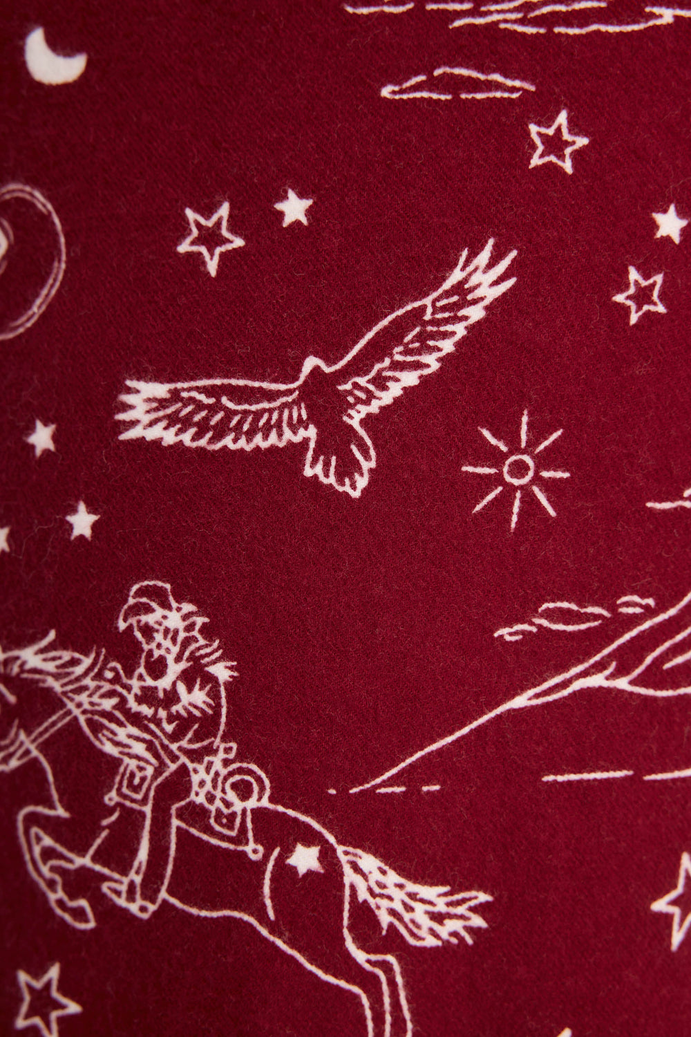 White line drawing on dark red DOGS PANT FLANNELS - port by P.J. Salvage, featuring a cowboy on horseback, an eagle, stars, clouds, and a sun in a Western-themed pattern.