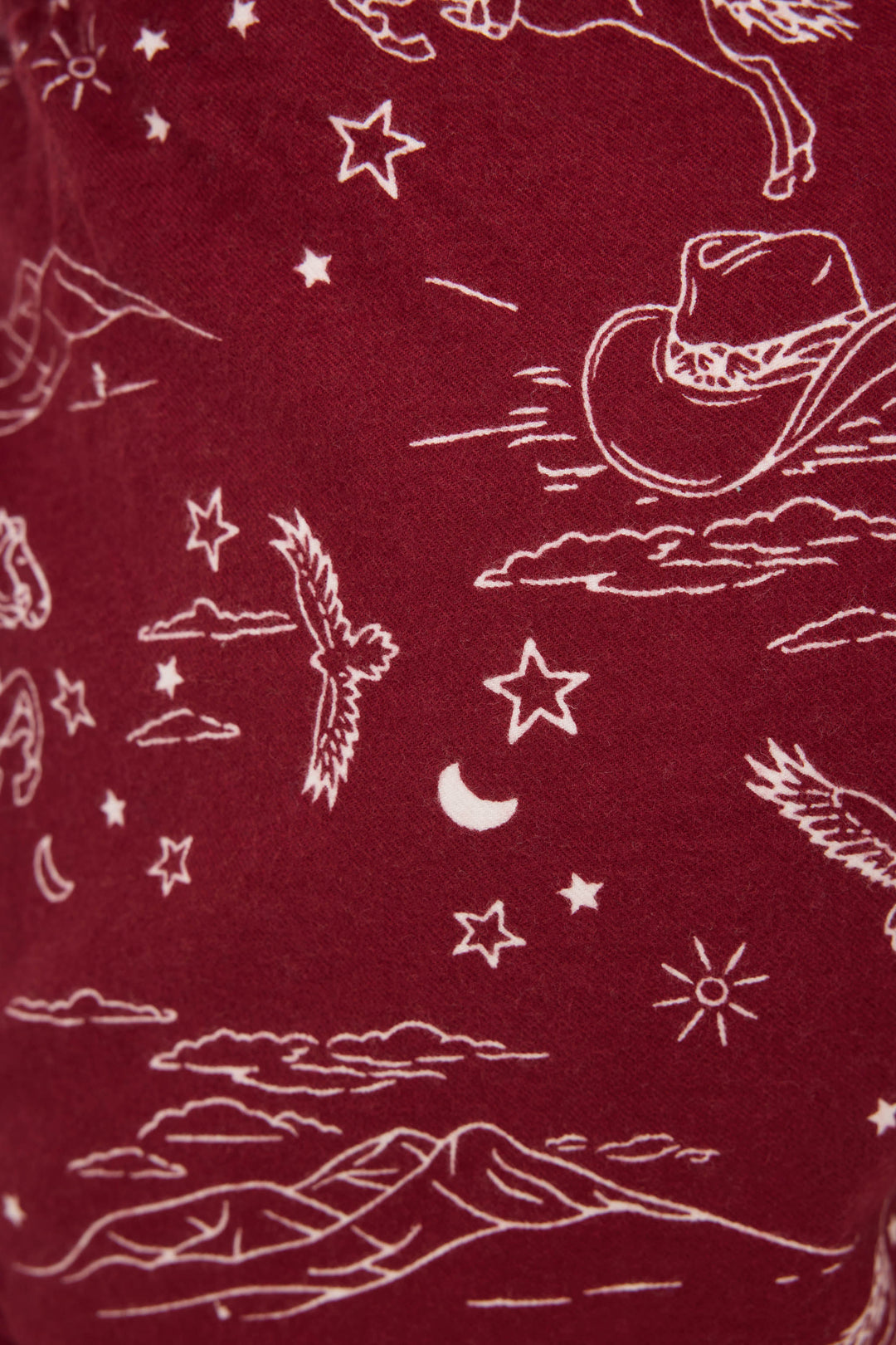 SHORT FLANNELS by P.J. Salvage: Maroon fabric with a white Western print featuring cowboy hats, horses, mountains, stars, clouds, a crescent moon, birds, and a sun.