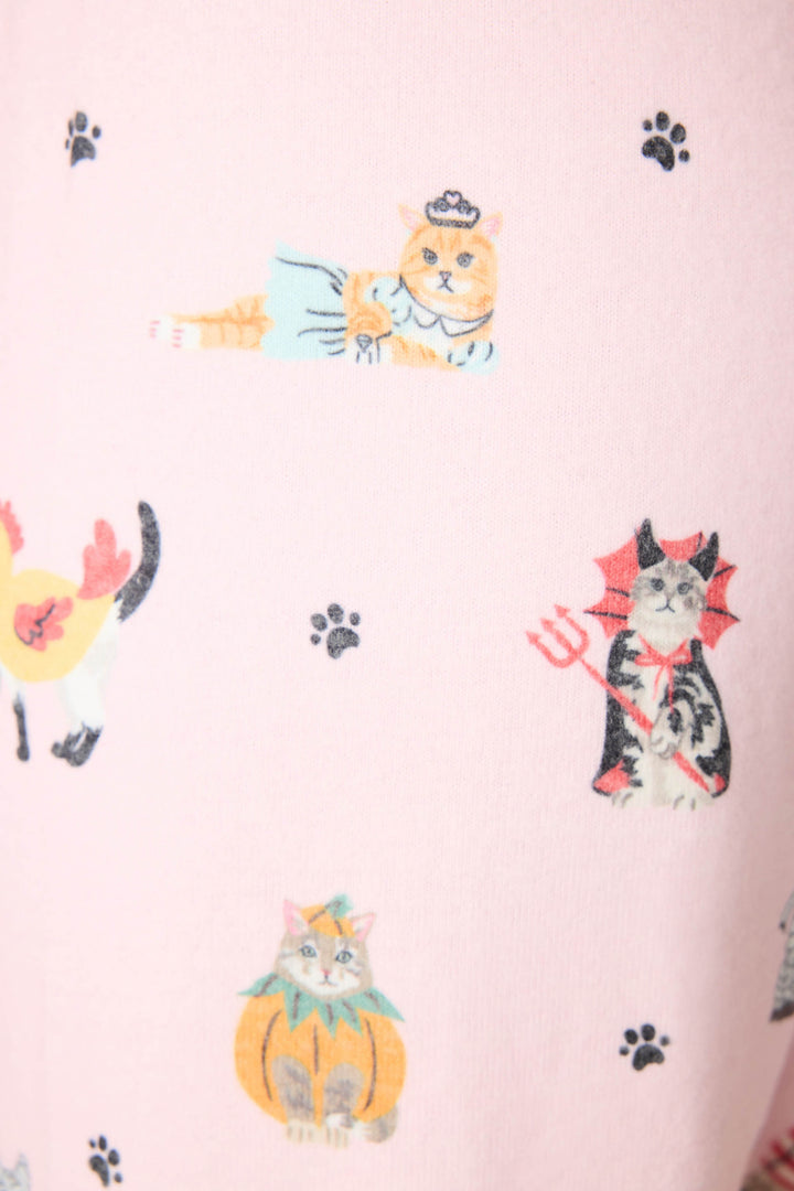 The P.J. Salvage CATS JAMMIE PANT FELINE SPOOKY features light pink fabric adorned with cats dressed as a mermaid, devil, lion, and pumpkin, plus small black paw prints scattered throughout.