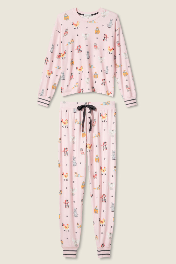 The P.J. Salvage CATS PJ SET FELINE SPOOKY is a pink pajama set with a long-sleeve top and pants, featuring playful animal and object prints, striped white/pink/black cuffs, and a black drawstring on the pants.
