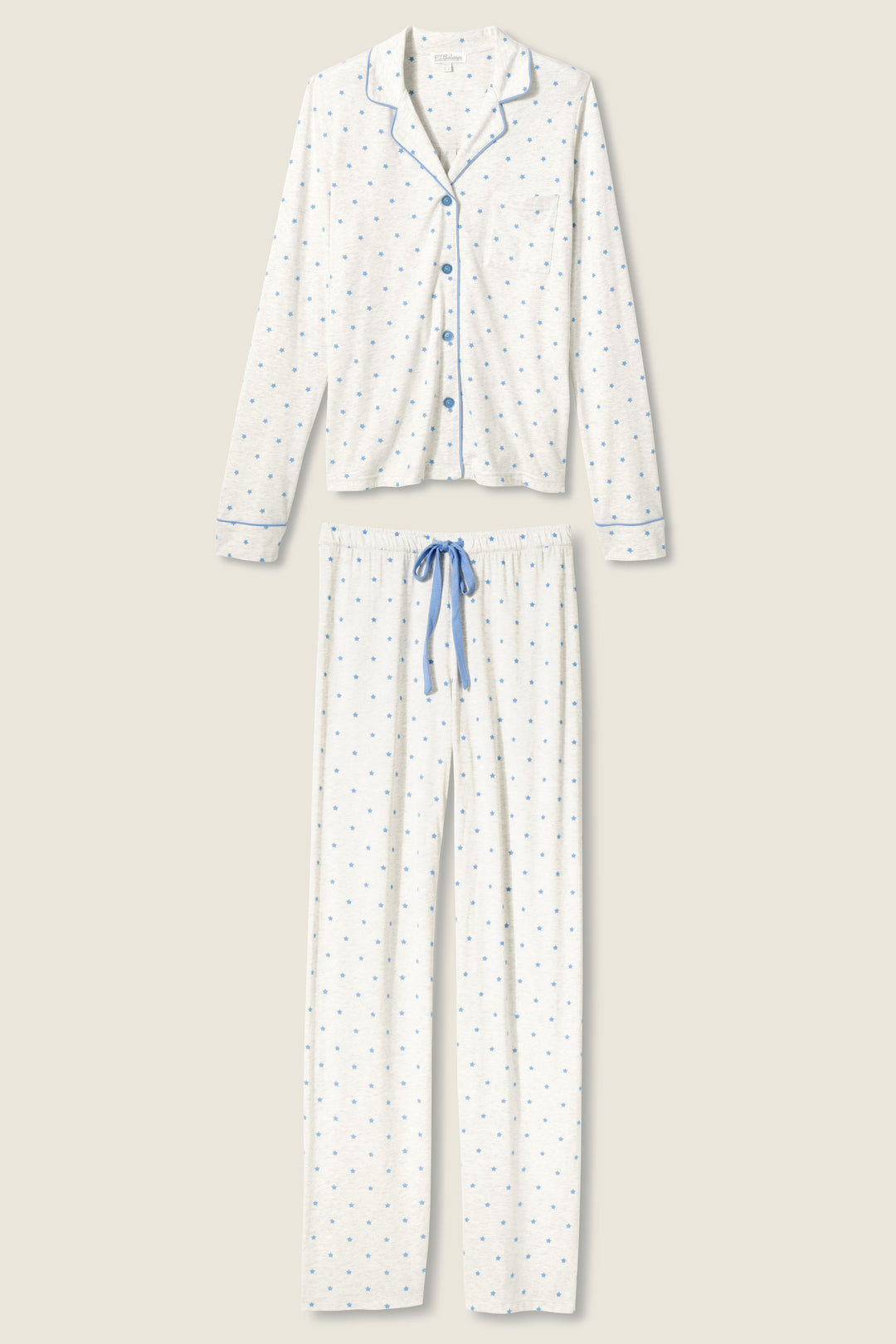 The P.J. Salvage Pant Set FLOCKING NOTCH COLLAR PJ SET LADY LUCK features a white two-piece pajama set with a long-sleeve, button-up top and matching pants. Both have a small blue pattern, blue trim and buttons, plus a blue drawstring waist on the pants.