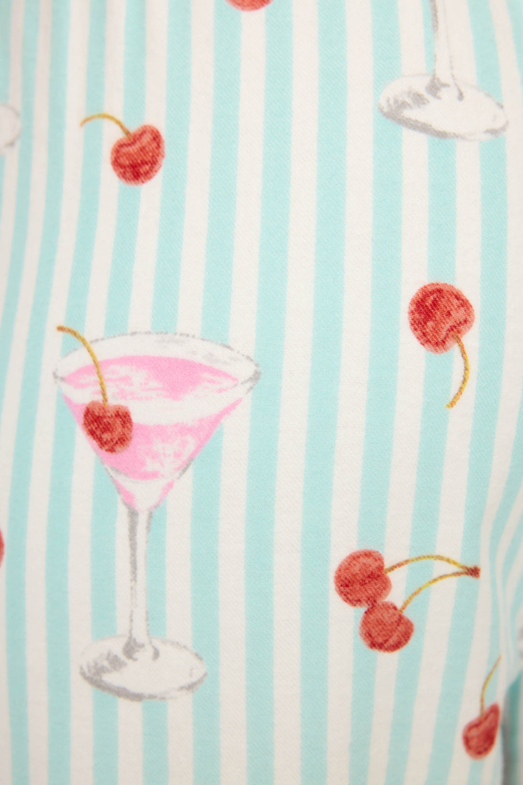 The DOGS PANT FLANNELS by P.J. Salvage feature pink cocktails in martini glasses with cherries and pairs of red cherries on vertical light blue and white stripes.