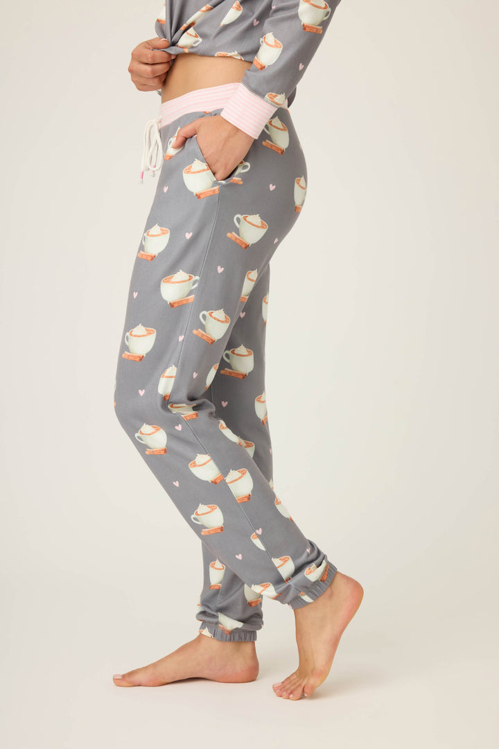 A person stands barefoot in P.J. Salvage’s Love You A Latte Coffee Print Banded Pant, with one hand in their pocket, against a plain light background.