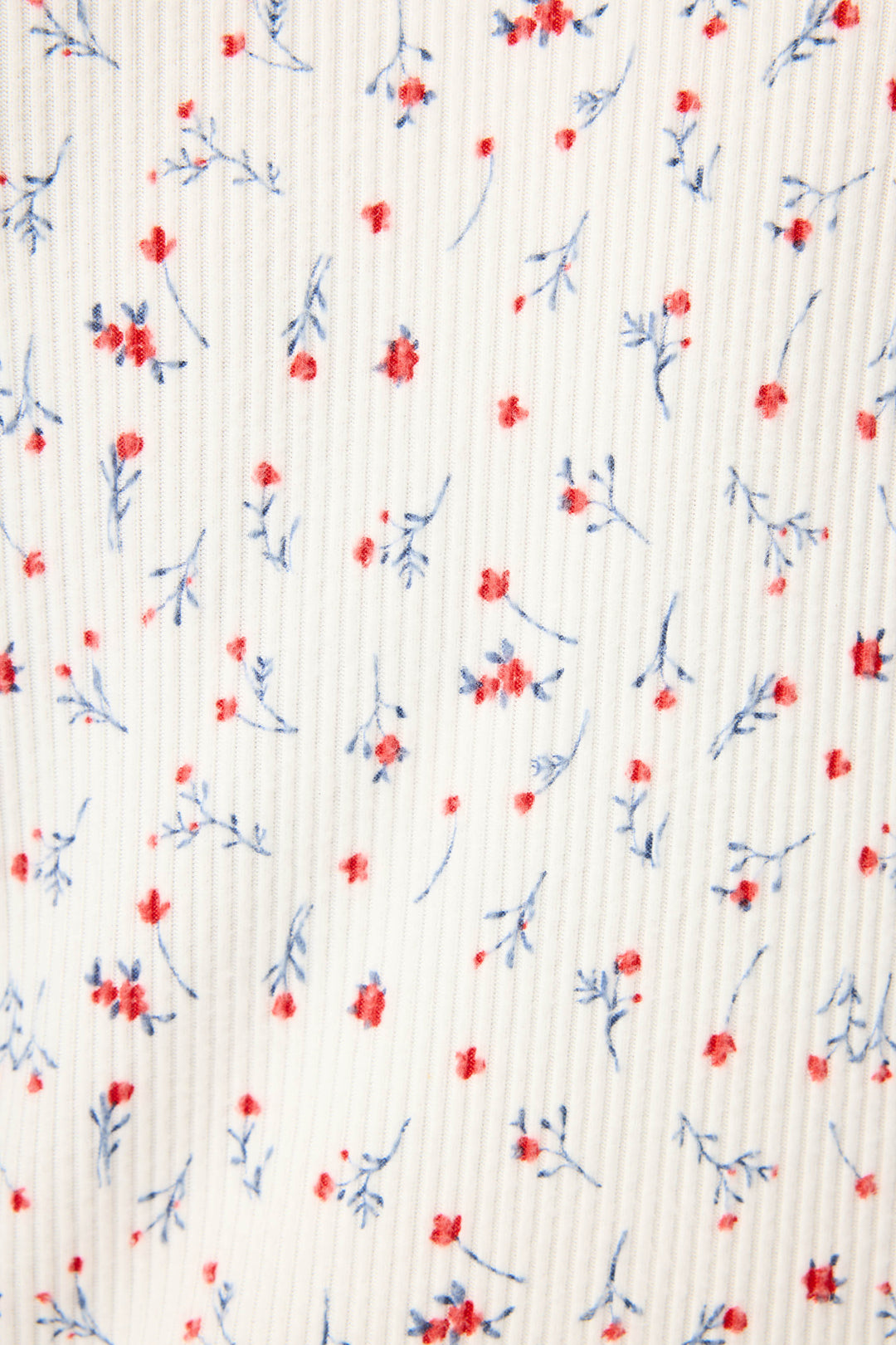 The ROSE CARDIGAN LA ROSE by P.J. Salvage features white fabric with a vertical ribbed texture, adorned with small red flowers and delicate blue stems and leaves throughout.