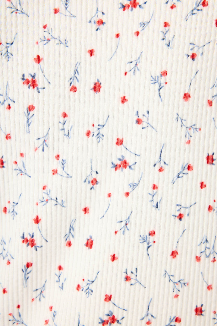 The ROSE CARDIGAN LA ROSE by P.J. Salvage features white fabric with a vertical ribbed texture, adorned with small red flowers and delicate blue stems and leaves throughout.