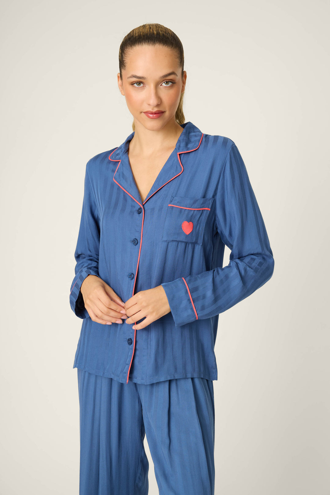 A woman with slicked-back hair wears the P.J. Salvage La Rose Striped Long Sleeve Top and stands facing forward against a plain, light background.