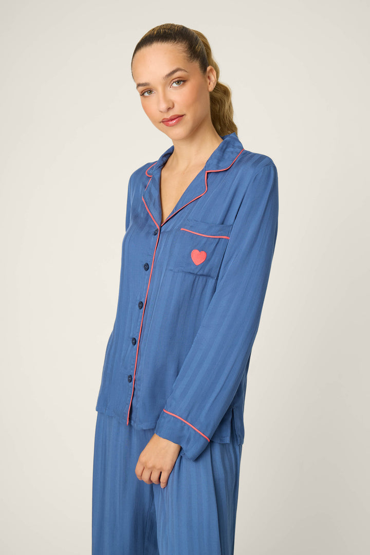 A person with long hair in a low ponytail is wearing the P.J. Salvage La Rose Striped Long Sleeve Top, standing against a plain light background.