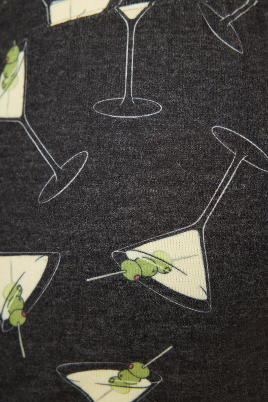 A close-up of the P.J. Salvage Merrier With A Martini Short, featuring dark fabric printed with martini glasses filled with yellow liquid and green olives on toothpicks.