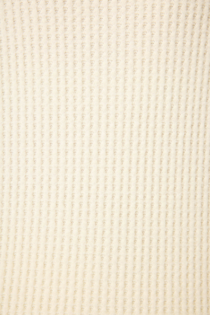 Close-up of the Morning Waffles Solid Ivory Long Sleeve Top by P.J. Salvage, featuring a cream-colored, ribbed textured fabric with a soft, evenly woven finish.