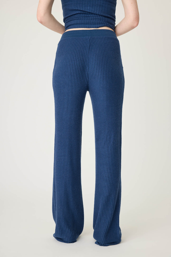 A person is shown from the waist down in P.J. Salvages Morning Waffles Solid Navy Open Leg Pant, featuring a textured, high-waisted design with a straight-leg fit against a plain light-colored background.