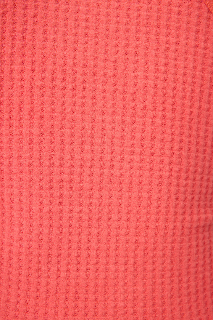 Close-up of the textured coral pink waffle knit fabric from P.J. Salvage’s Morning Waffles Scarlet Loungewear Set, displaying a regular grid pattern with raised and recessed areas.