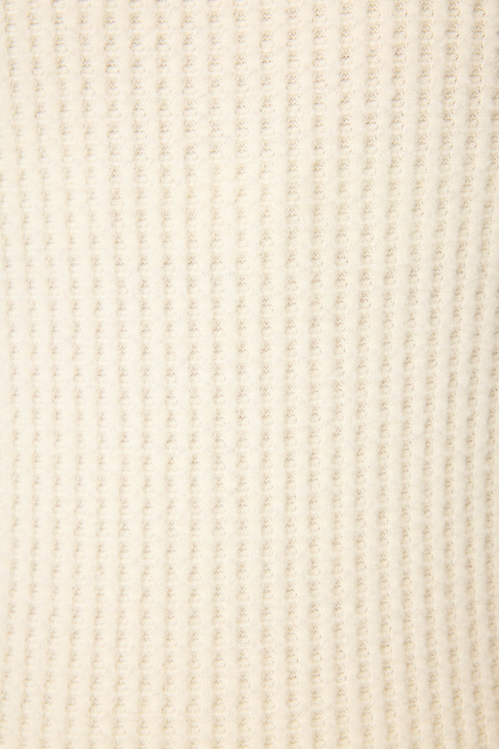 Close-up of a soft, cream-colored ribbed fabric with vertical lines, featured in P.J. Salvage’s Morning Waffles Natural Shorts—perfect for cozy loungewear.