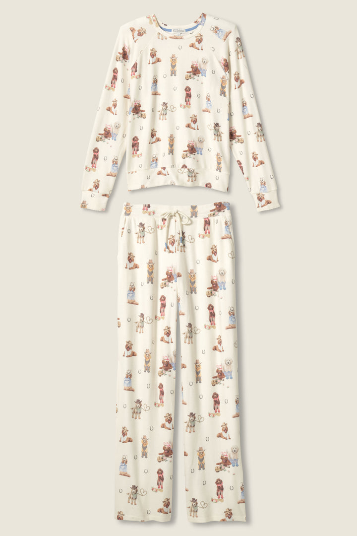 The P.J. Salvage DOGS PJ SET RUFF ON THE RANGE features a long-sleeve top and drawstring pants with a cartoon dog print on a cream background, displayed flat on a neutral surface.