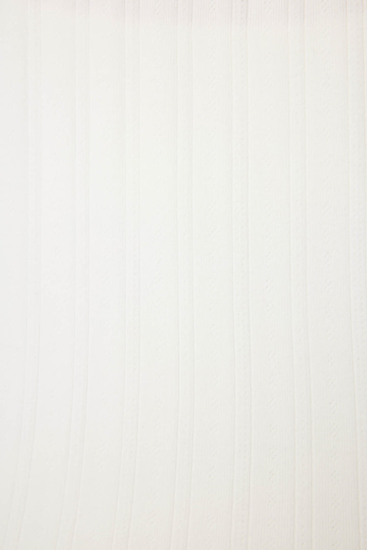 The Pointelle Essentials Solid Ivory Cardigan by P.J. Salvage features a white textured surface with vertical, slightly wavy lines and subtle embossed patterns evenly spaced across the background.