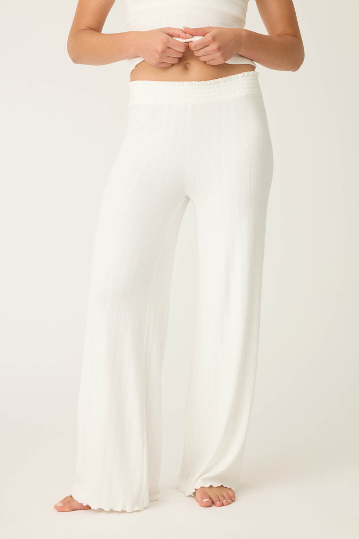 A person stands barefoot in P.J. Salvage’s Pointelle Essentials Solid Ivory Open Leg Pant, featuring a high elastic waistband and loose, wide-leg fit. The cropped photo shows only the pants against a plain light background.
