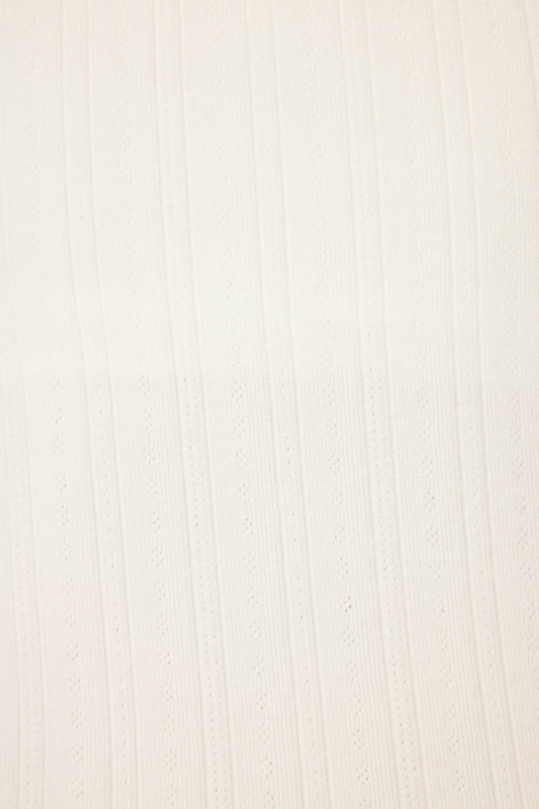 A close-up of the P.J. Salvage Pointelle Essentials Solid Ivory Shorts shows white textured fabric with vertical ribbed and perforated patterns running parallel across the surface.