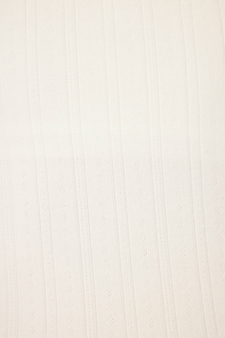 A close-up of the P.J. Salvage Pointelle Essentials Solid Ivory Shorts shows white textured fabric with vertical ribbed and perforated patterns running parallel across the surface.