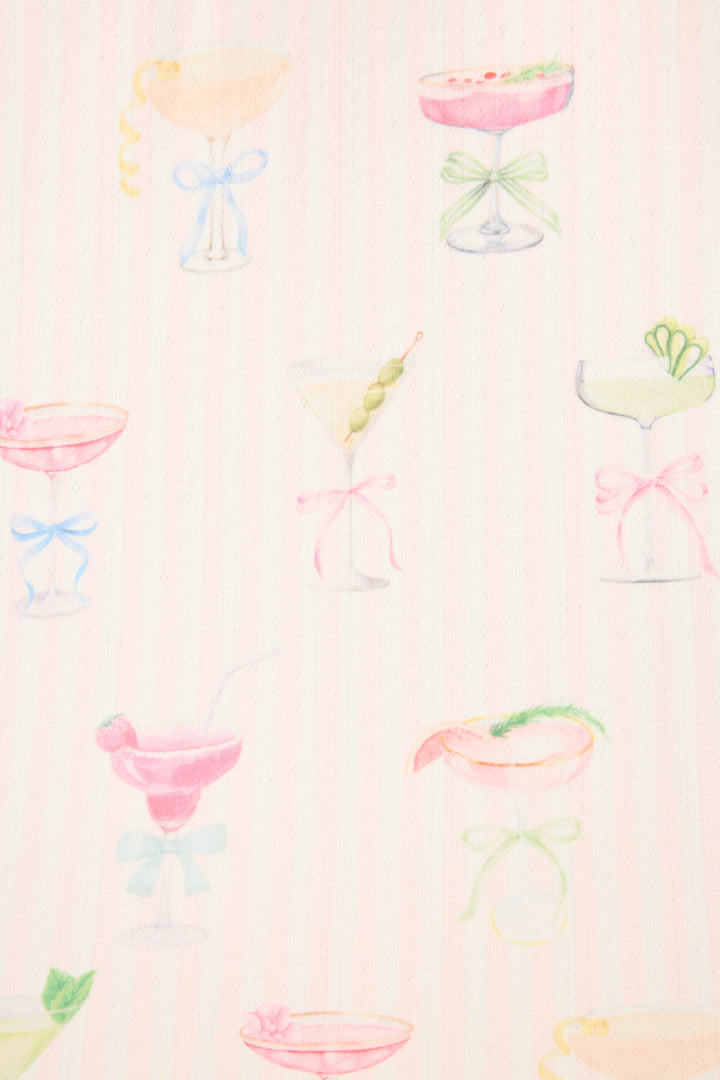 The P.J. Salvage Pretty Punch Cocktail Print Long Sleeve Top showcases pastel cocktail glasses with garnishes and bows on a soft pink background.