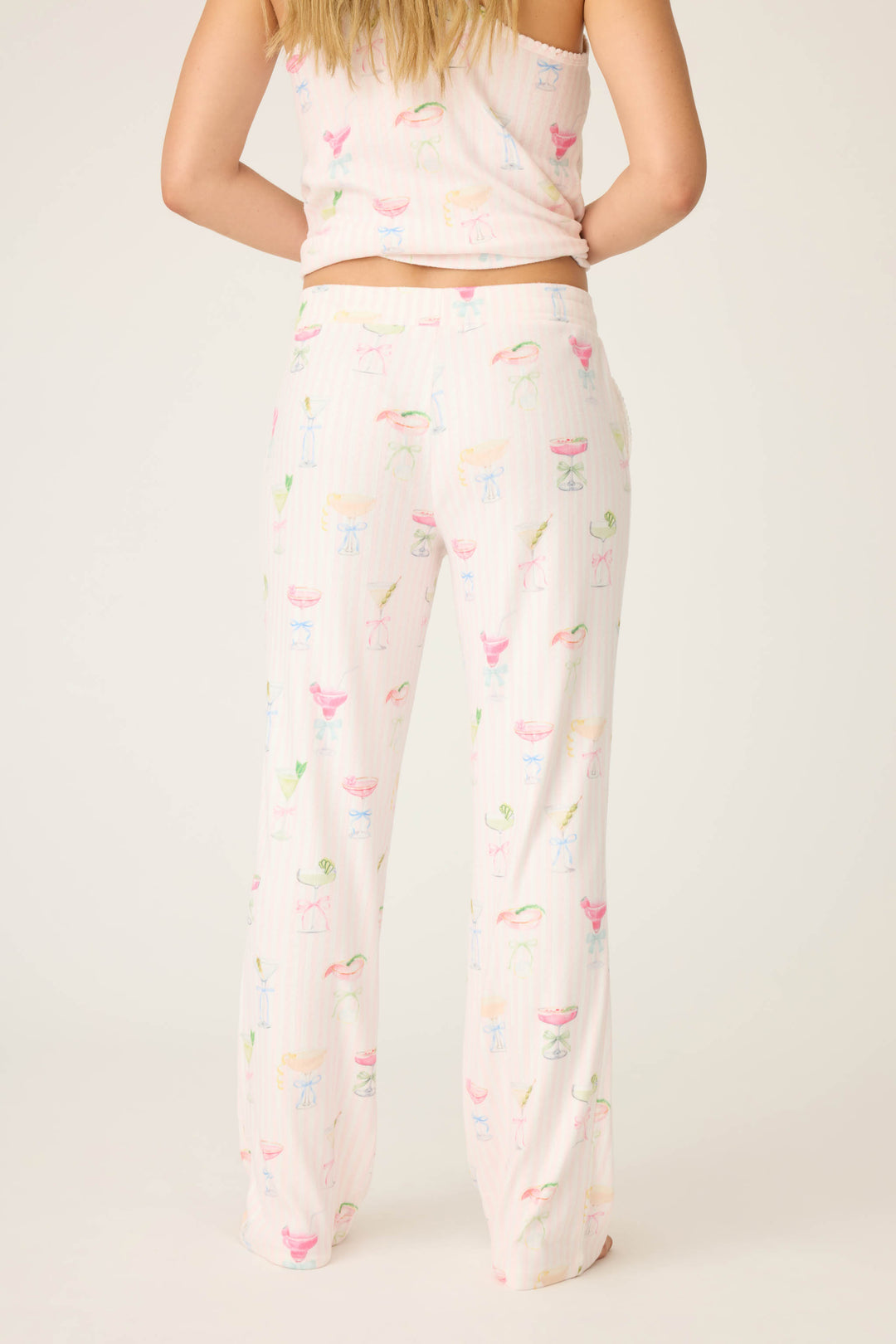 A person wearing P.J. Salvages Pretty Punch Cocktail Print Open Leg Pants stands with their back to the camera, showcasing the colorful, playful pattern against a plain background.