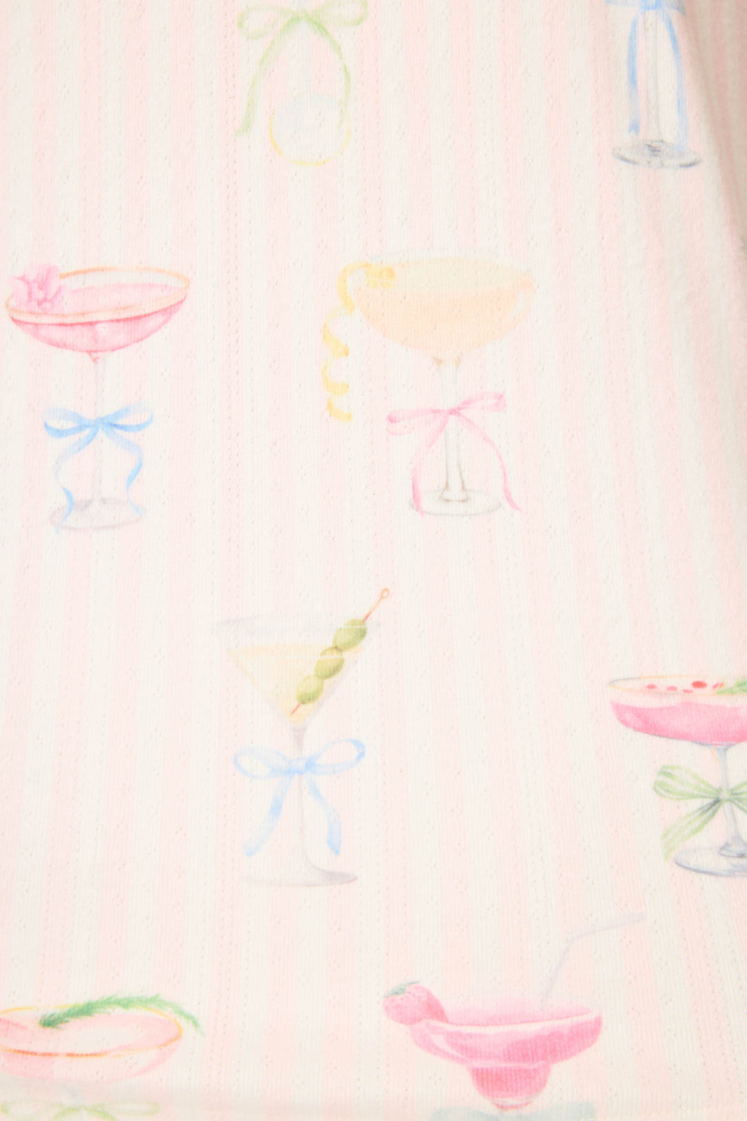 The P.J. Salvage Pretty Punch Cocktail Print Open Leg Pants feature pastel cocktail glasses with garnishes and bows on a light pink, subtly striped background.