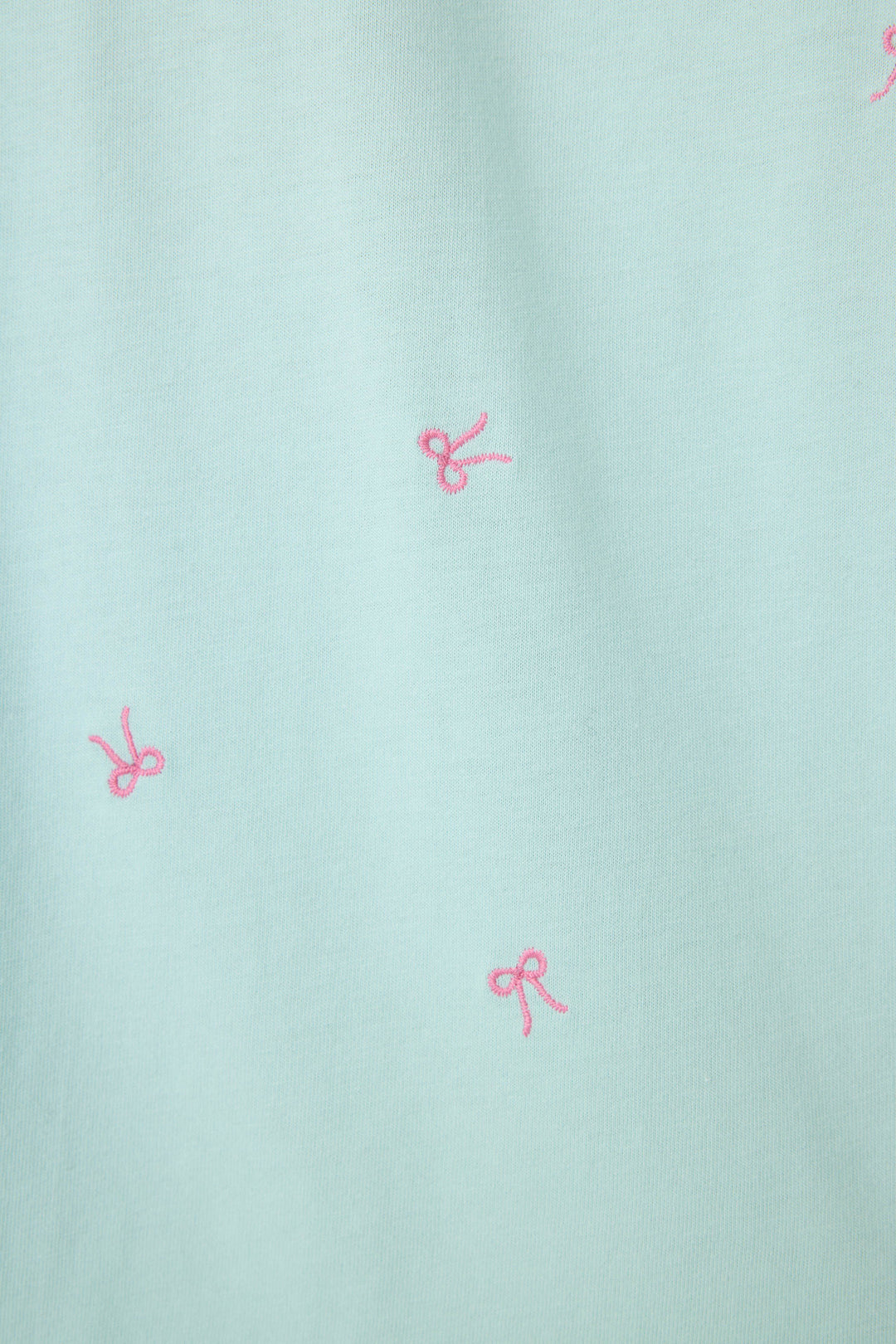 The P.J. Salvage Pretty Punch Bow Print Loungewear Short Set features smooth light blue fabric with small, irregularly placed embroidered pink bows for a charming, playful look.