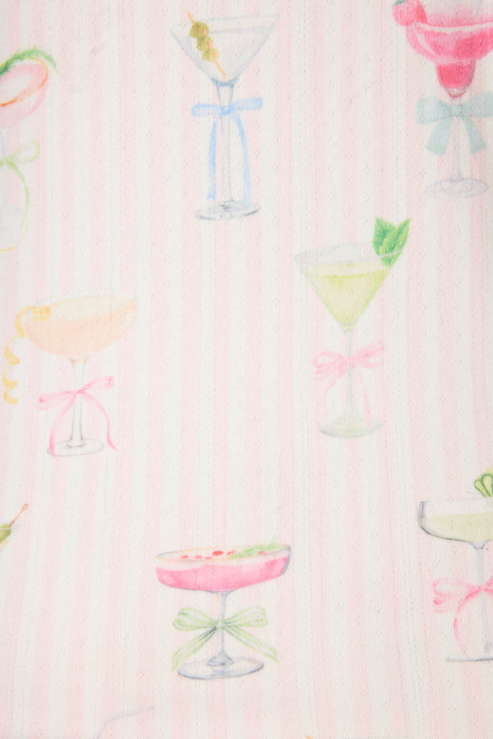 The Pretty Punch Cocktail Print Shorts by P.J. Salvage feature a pale pink and white striped background with scattered watercolor-style cocktail glasses, some adorned with garnishes and bows.