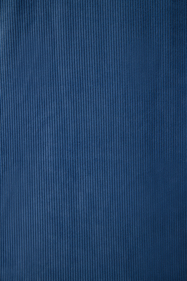 Close-up of the Craving Corduroy Velour Lounge Set by P.J. Salvage highlights its blue velour fabric with vertical ridges and a soft, textured surface, featuring even color and a consistent ribbed pattern throughout.