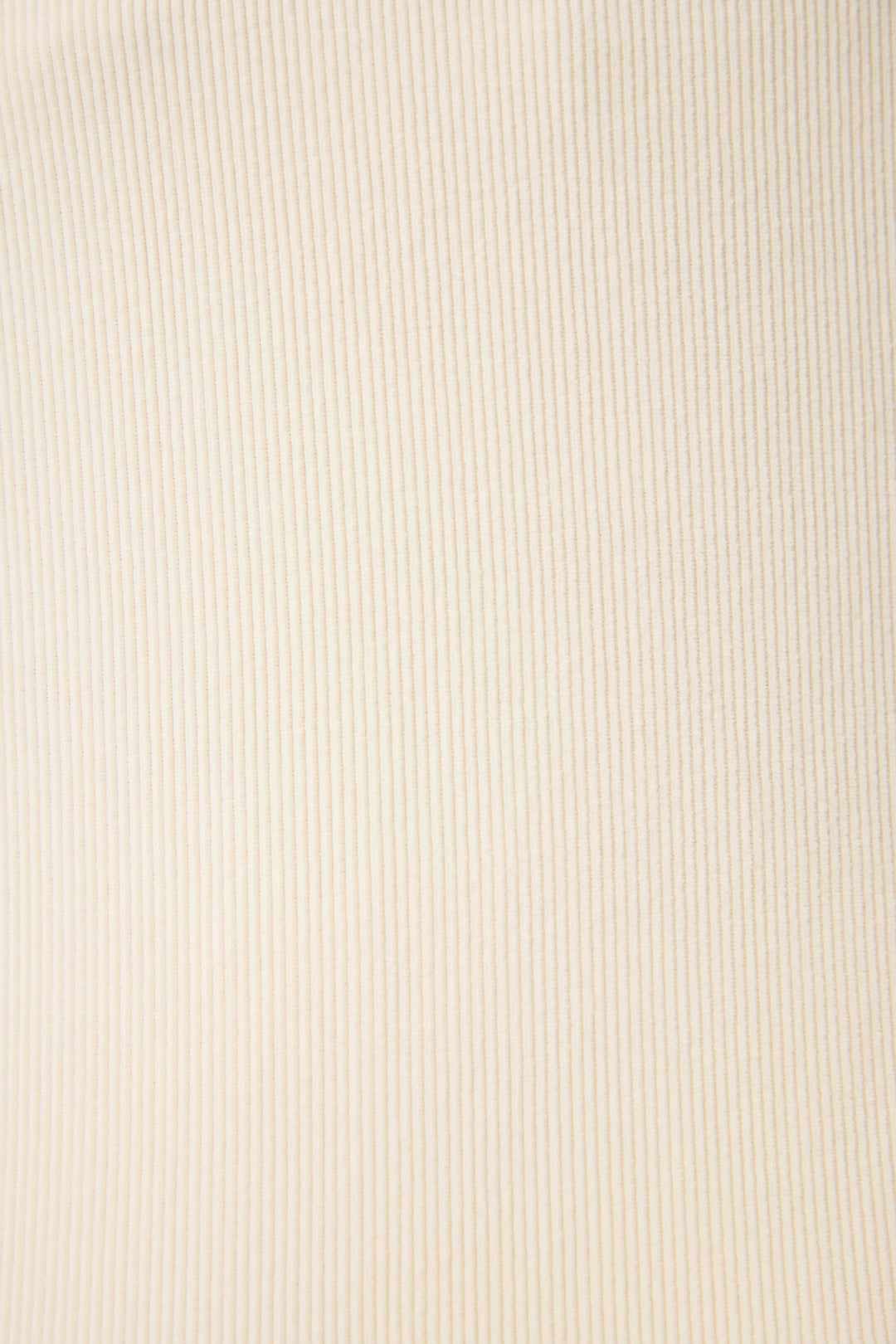Close-up of SOLID PJ SET CRAVING CORDUROY by P.J. Salvage, featuring beige ribbed fabric with vertical textured lines. Even lighting enhances the detailed texture and softness of the material.
